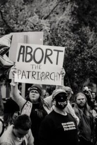 Group of activists at a protest holding signs promoting gender equality and social justice.