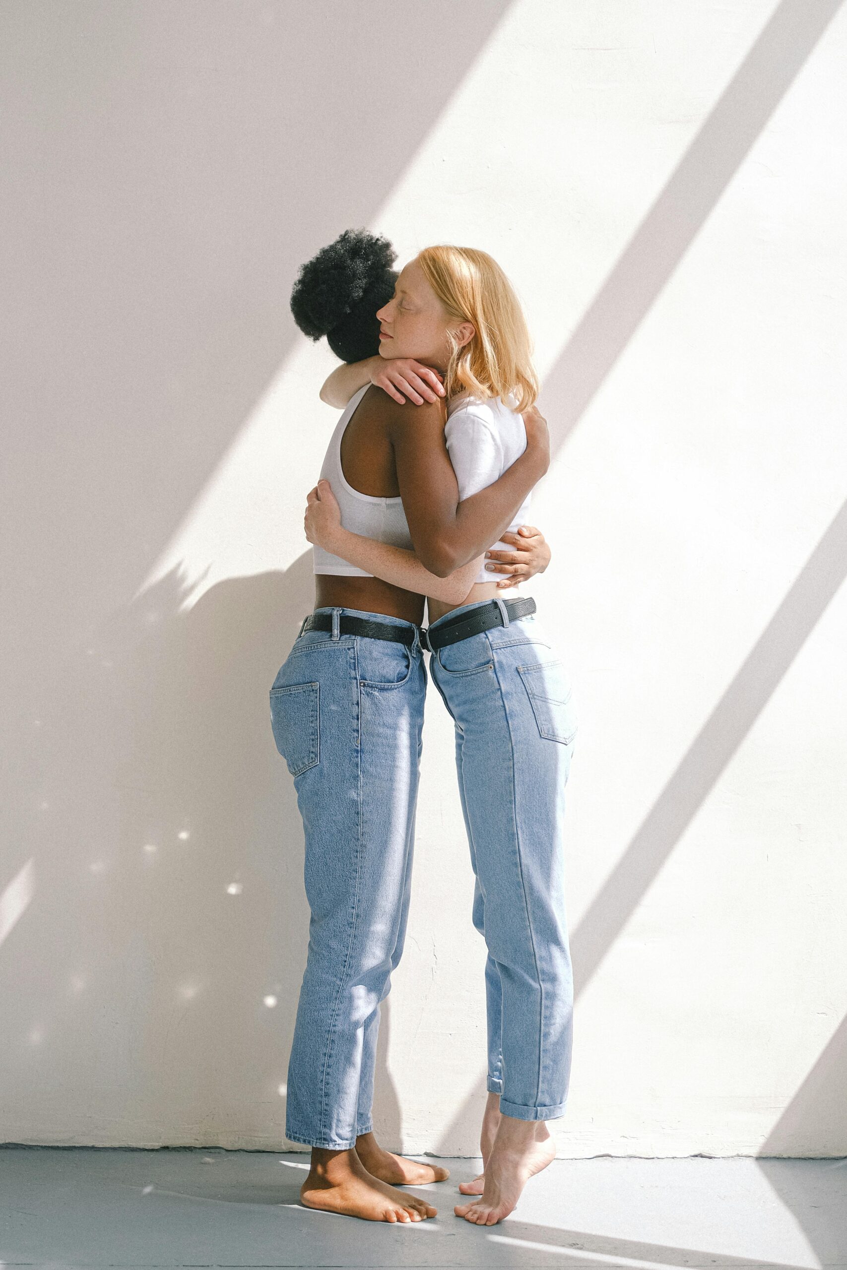 A loving interracial couple sharing a warm hug in bright natural light.